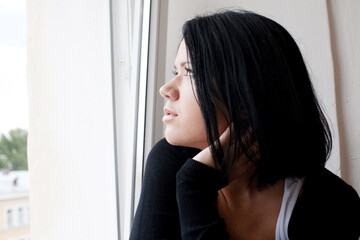 woman looking through a window.