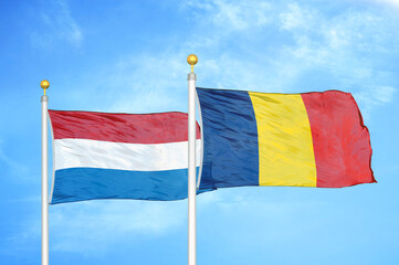 Netherlands and Chad two flags on flagpoles and blue sky