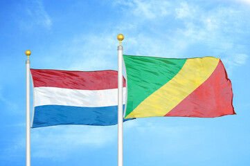 Netherlands and Congo two flags on flagpoles and blue sky