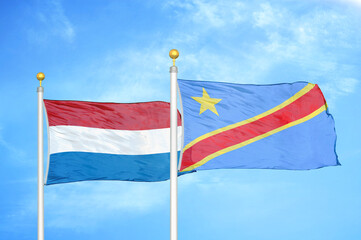 Netherlands and Congo Democratic Republic two flags on flagpoles and blue sky