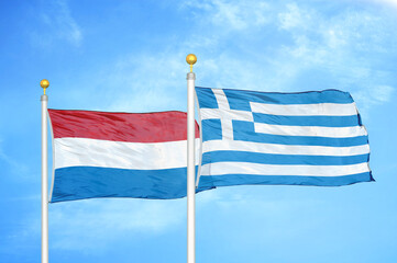 Fototapeta premium Netherlands and Greece two flags on flagpoles and blue sky