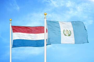 Netherlands and Guatemala two flags on flagpoles and blue sky
