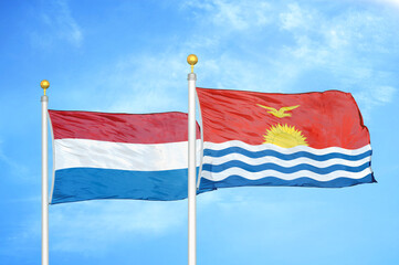 Netherlands and Kiribati two flags on flagpoles and blue sky