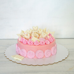 A pink creamchease cake with flowers for 5 year birhtday