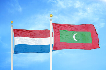 Netherlands and Maldives two flags on flagpoles and blue sky