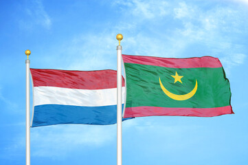 Netherlands and Mauritania two flags on flagpoles and blue sky