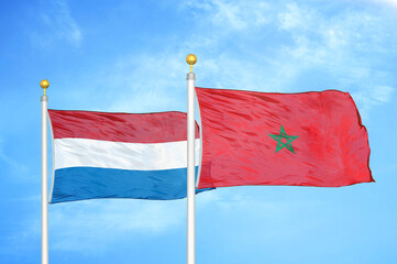 Netherlands and Morocco two flags on flagpoles and blue sky