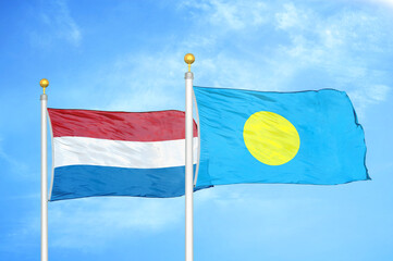 Netherlands and Palau two flags on flagpoles and blue sky