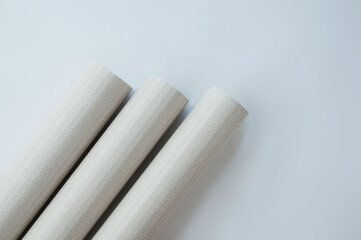 Three rolls gray paper wallpaper for wall renovation. View from above.