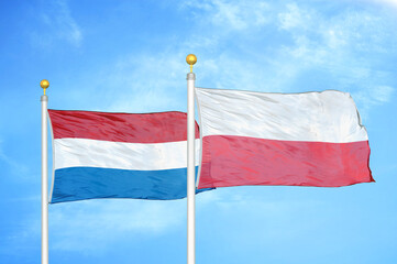 Netherlands and Poland two flags on flagpoles and blue sky