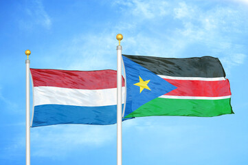 Netherlands and South Sudan two flags on flagpoles and blue sky