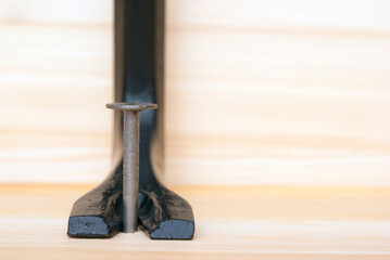 One iron nail and scrap on a wooden board