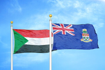 Sudan and Cayman Islands two flags on flagpoles and blue sky