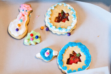 Tray gift paper box filled with many decorated icing glazed with candy sugar colorful artificial blue sprinkles Christmas holiday baked homemade cookies, snowmen, trees