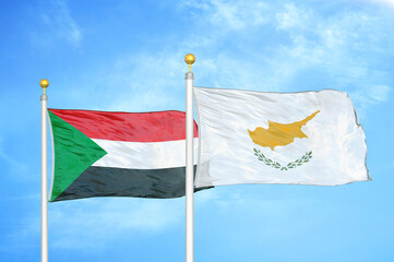 Sudan and Cyprus two flags on flagpoles and blue sky