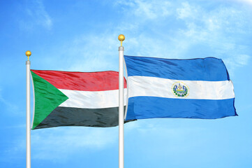 Sudan and El Salvador two flags on flagpoles and blue sky