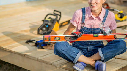 Carpenter woman is at work. Building as a hobby. Beautiful woman with construction tools