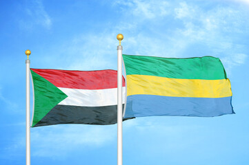 Sudan and Gabon two flags on flagpoles and blue sky