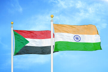 Sudan and India two flags on flagpoles and blue sky