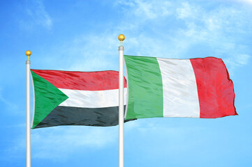 Sudan and Italy two flags on flagpoles and blue sky