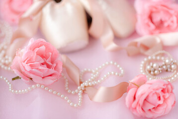 Ballerina pointe shoes are classic ballet shoes with pearl decorations and roses on pink fabric. Ballet shoes selective focus. © Victor