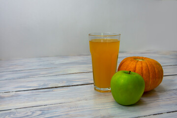 Glass of freshly squeezed green apple and pumpkin juice. Vegan food, detox diet. Healthy food concept. Selective focus, copy space