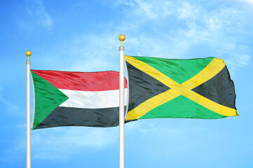 Sudan and Jamaica two flags on flagpoles and blue sky