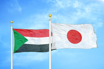 Sudan and Japan two flags on flagpoles and blue sky