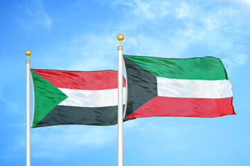 Sudan and Kuwait two flags on flagpoles and blue sky