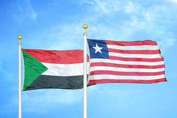 Sudan and Liberia two flags on flagpoles and blue sky