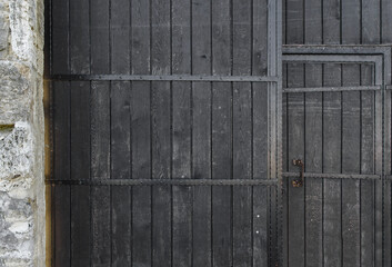 Black and old wooden door texture with iron stripes