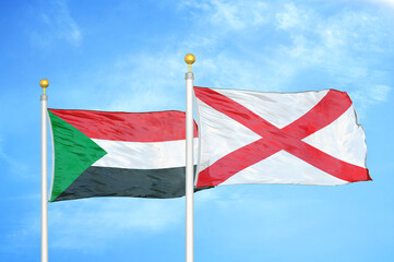 Sudan and Northern Ireland two flags on flagpoles and blue sky