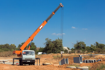 truck crane with hydraulic system lifts concrete structures for construction of drainage system in the ground, nobody.