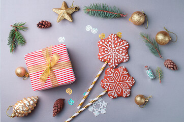 Beautiful packaged gift with gold ribbon, sequins, toys, bumps, sprigs of Christmas trees, gingerbread in the form of snowflakes. Holiday content