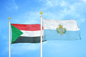 Sudan and San Marino two flags on flagpoles and blue sky