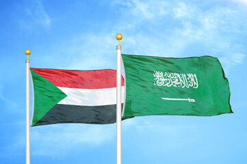 Sudan and Saudi Arabia two flags on flagpoles and blue sky