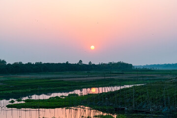 Sunset landscape with red sun over the horizon of a river