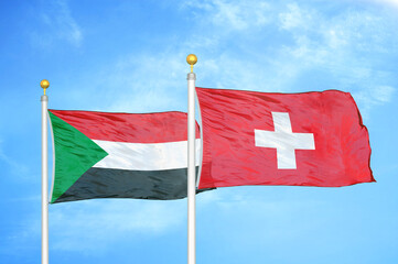 Sudan and Switzerland two flags on flagpoles and blue sky