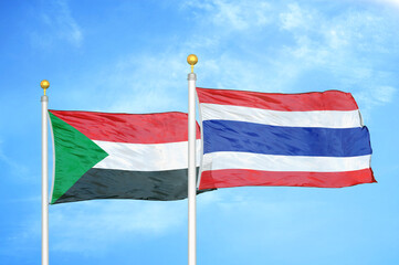 Sudan and Thailand two flags on flagpoles and blue sky