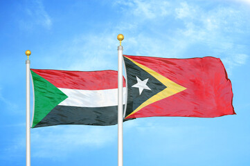 Sudan and Timor-Leste East Timor two flags on flagpoles and blue sky