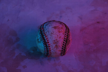 Baseball ball in purple and blue lighting for sports.