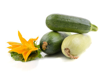 three fresh zucchini with green leaves and flower isolated on a white background