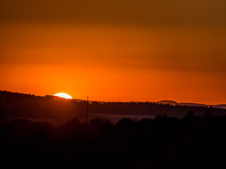 Naklejka premium Sonnenuntergang hinter Hügelkette