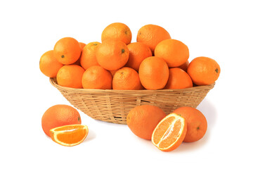 Oranges in a big wicker basket with half and slice isolated on white