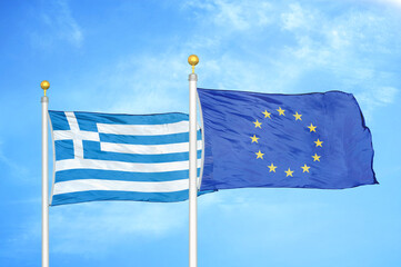 Greece and European Union two flags on flagpoles and blue sky