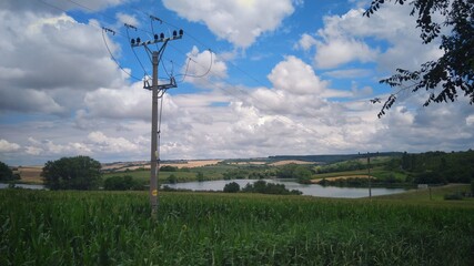 Fototapeta na wymiar energy pole in the field near the lake
