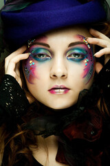 Beautiful woman in hat with artistic make-up.