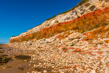 A view of major rockfalls from the white, red and orange stratified cliffs at Old Hunstanton, Norfolk, UK