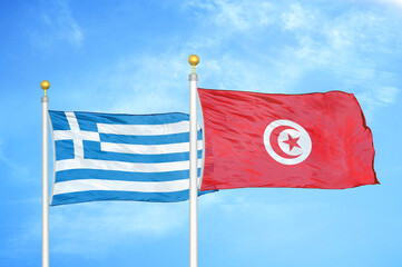 Greece and Tunisia two flags on flagpoles and blue sky