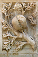 Relief of a pomegranate fruit with the seeds in an old facade, symbol of the city of Ganada (Spain)